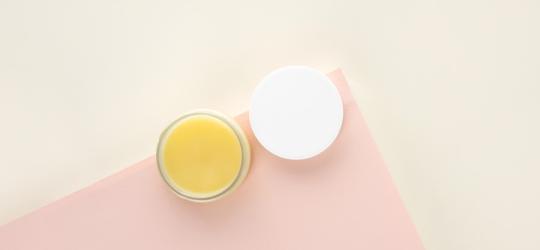 Lanolina w niewielkim słoiczku na kosmetyki.