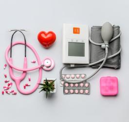 Leki na nadciśnienie obok ciśnieniomierza, stetoskopu i kasetki na leki.