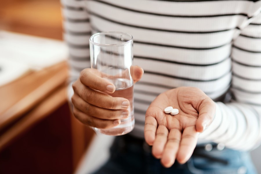 Kobieta zażywa leki łagodzące objawy menopauzy.