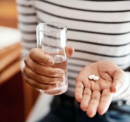 Kobieta zażywa leki łagodzące objawy menopauzy.