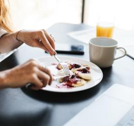 Kobieta spożywa posiłek.