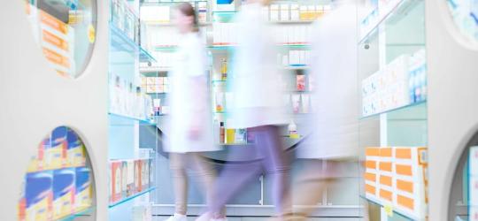Farmaceuci poruszający się po aptece.