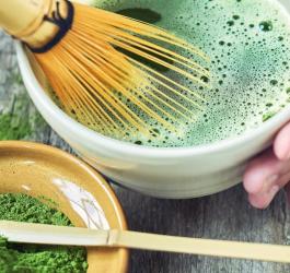 Osoba przygotowuję herbatę matcha tradycyjnym sposobem.