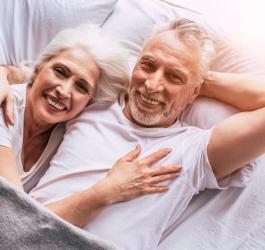 Para szczęśliwych seniorów leży na materacu medycznym.