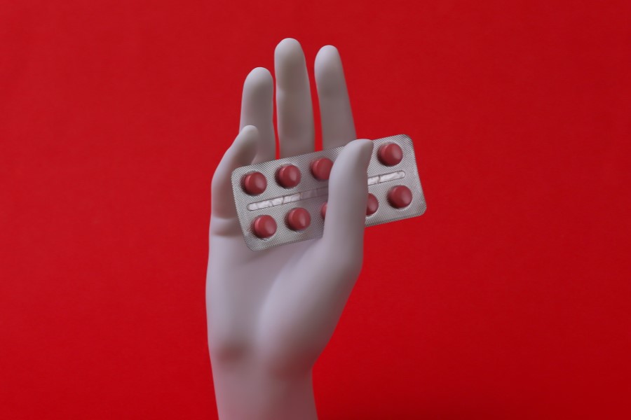 Blister tabletek z meloksykamem w dłoni manekina.