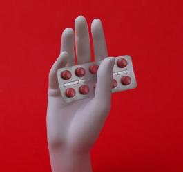 Blister tabletek z meloksykamem w dłoni manekina.