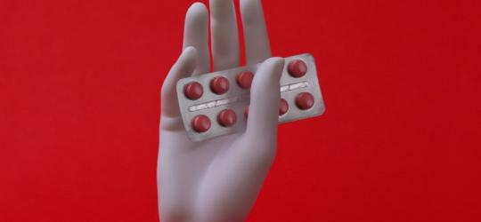 Blister tabletek z meloksykamem w dłoni manekina.