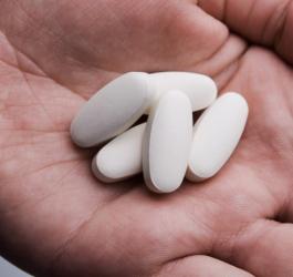 Pacjent trzyma w dłoni tabletki z metronidazolem.