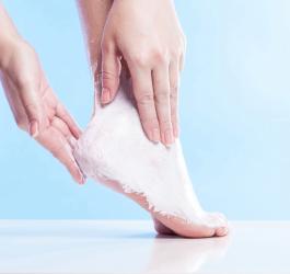 Kobieca stopa podczas intensywnego peelingu na modzele.