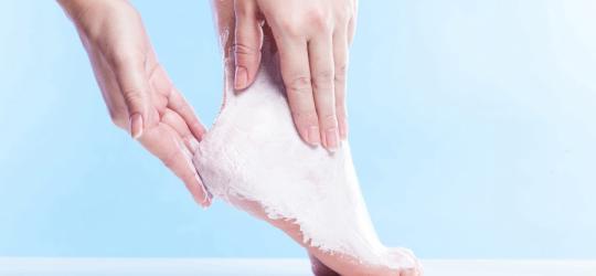 Kobieca stopa podczas intensywnego peelingu na modzele.