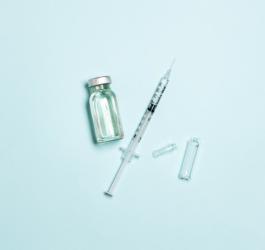 Fiolka zawierająca morfinę i strzykawka na błękitnym tle.