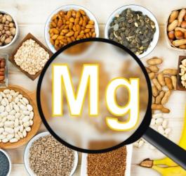 Źródła magnezu (nasiona, orzechy, kasze, strączki i owoce) ułożone z miseczkach.