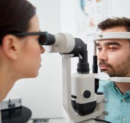 Mężczyzna bada się u okulisty w kierunku diagnostyki nadciśnienia w oku.