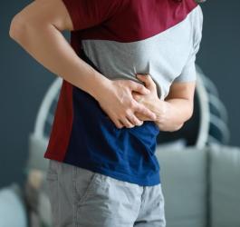 Mężczyzna trzyma się za bok, cierpi na nadciśnienie wrotne.