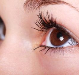 Zbliżenie na oko kobiety z pomalowanymi rzęsami.