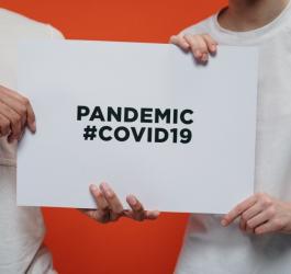 Dwóch mężczyzn trzyma kartkę z napisem