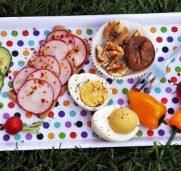 Tacka pełna świeżych warzyw, orzechów i bakalii oraz ugotowanych jajek.