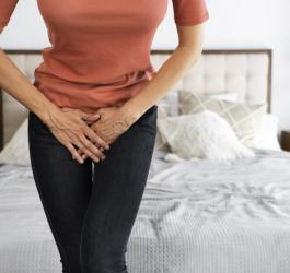 Kobieta trzyma się za podbrzusze.