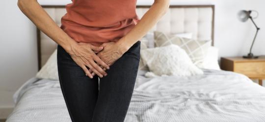 Kobieta trzyma się za podbrzusze.
