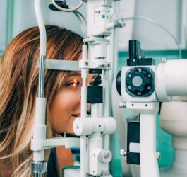 Kobieta ma wykonywane badanie dna oka w gabinecie okulistycznym.
