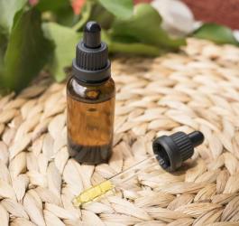 Buteleczka olejku CBD oraz pipeta wypełniona olejkiem.