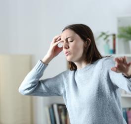 Kobieta w trakcie omdlenia, traci równowagę.