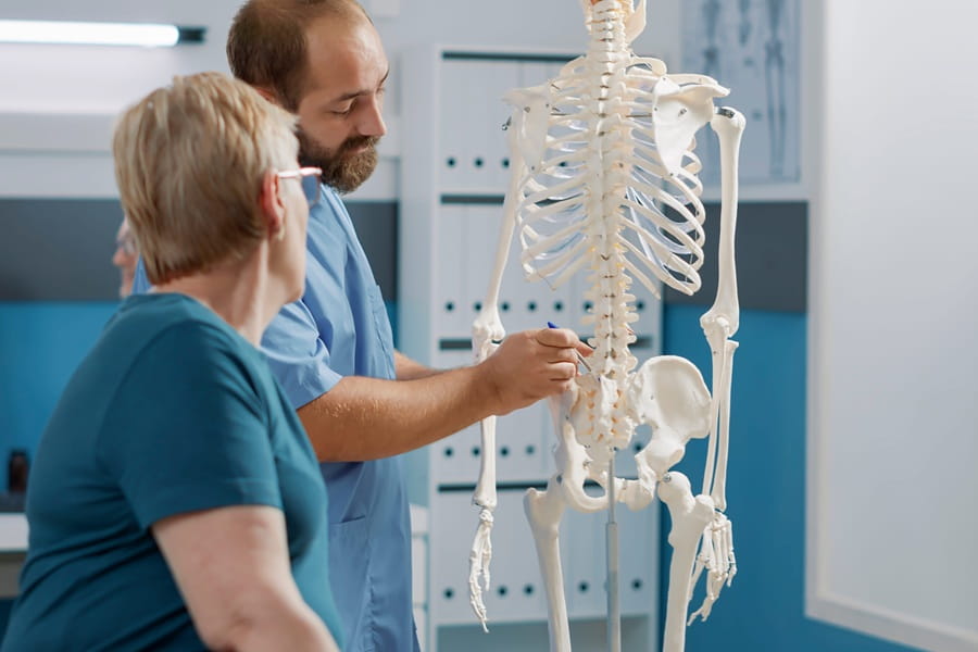 Lekarz tłumaczy pacjentce, czym jest osteomalacja.