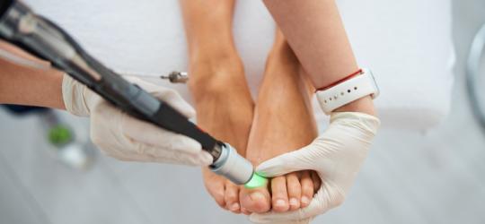 Kobiece stopy podczas zabiegu podologicznego.