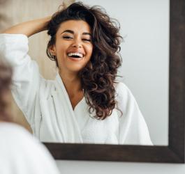 Zadowolona kobieta po wykonanym peelingu skóry głowy.