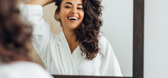 Zadowolona kobieta po wykonanym peelingu skóry głowy.