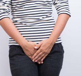 Kobieta trzyma dłonie na wysokości narządów rodnych. Może cierpieć na pochwicę.