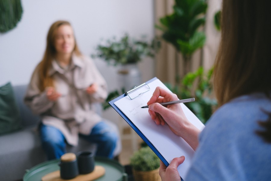 Kobieta w poradni psychologicznej podczas spotkania z psychoterapeutką.