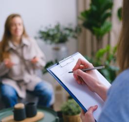 Kobieta w poradni psychologicznej podczas spotkania z psychoterapeutką.