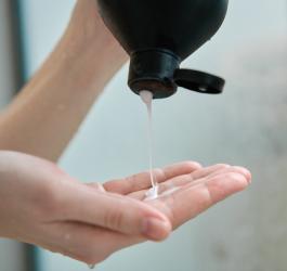 Osoba nalewa na dłoń porcję szamponu do włosów.