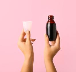 Kobieta trzyma w dłoniach syrop przeznaczony do odrobaczania organizmu.