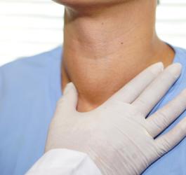 Lekarz bada u pacjenta przerost tarczycy.