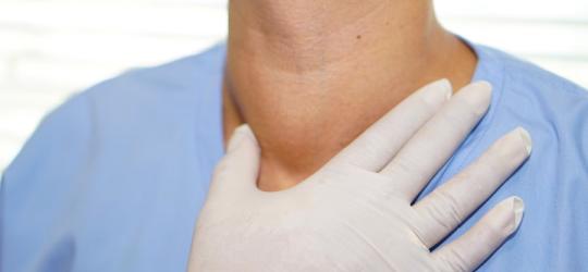 Lekarz bada u pacjenta przerost tarczycy.