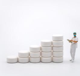 Wykres wzrostu sprzedaży leków zbudowany z tabletek.