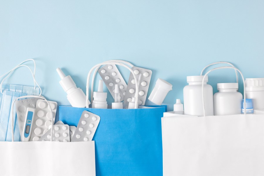 Różnorodne leki w papierowych torbach na zakupy.