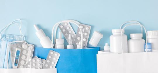 Różnorodne leki w papierowych torbach na zakupy.