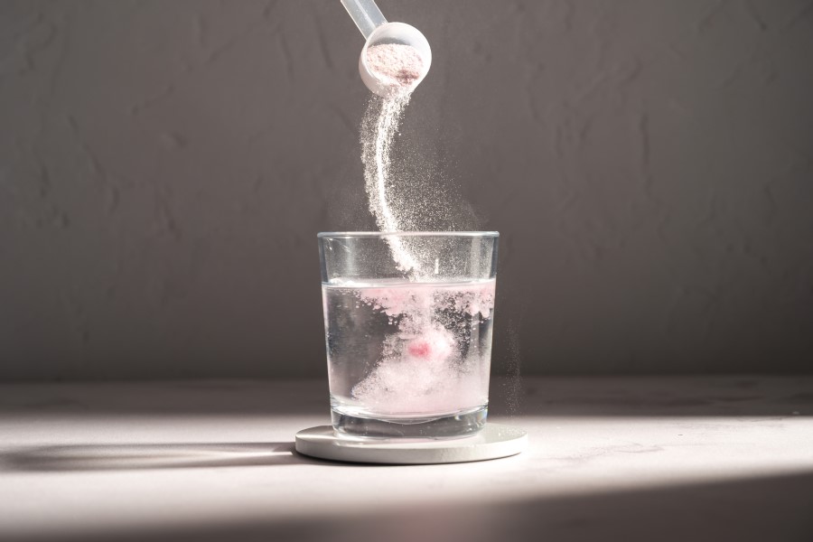 Kolagen w proszku rozpuszczany w szklance wody.