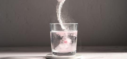 Kolagen w proszku rozpuszczany w szklance wody.