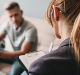 Mężczyzna i terapeutka w trakcie sesji terapii skoncentrowanej na rozwiązaniach.