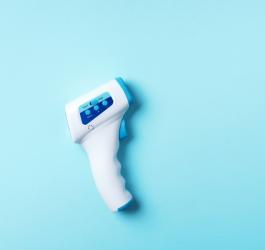 Termometr bezdotykowy na błękitnym tle.