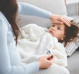Mama mierzy dziecku temperaturę, może mieć trzydniówkę.