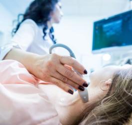 Pacjentka jest w trakcie badania USG węzłów chłonnych przez lekarza.