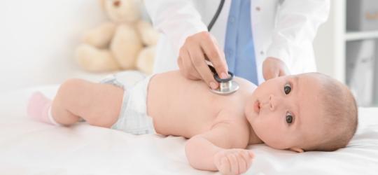 Niemowlę jest badane stetoskopem przez pediatrę.