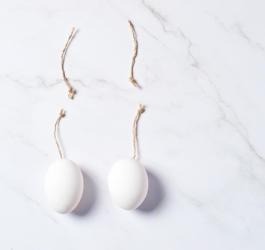 Ceramiczne jajka z odciętymi sznureczkami, symbolizujące zabieg wazektomii.