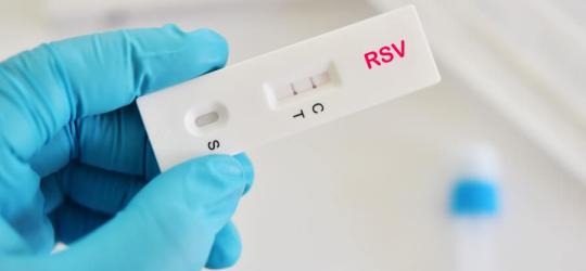 Diagnosta trzyma w dłoni test na wirusa RSV.