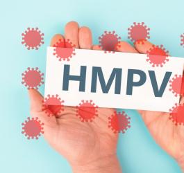 Osoba trzyma w dłoniach kartę z napisem wirus HMPV.